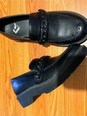 Black loafers with chain detailing